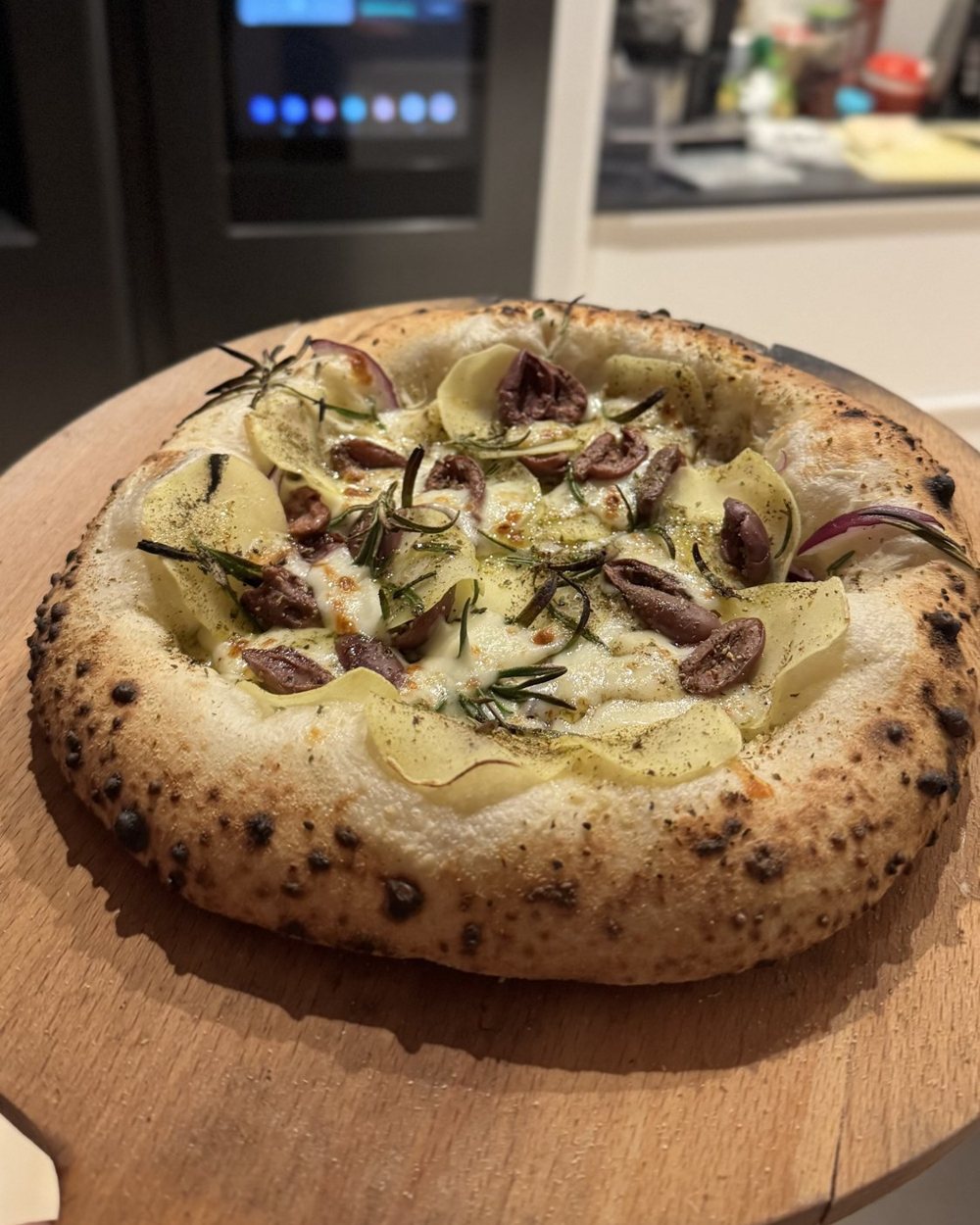 Hjemmebagt neapolitansk pizza på en træpizzaskovl i Jespers køkken