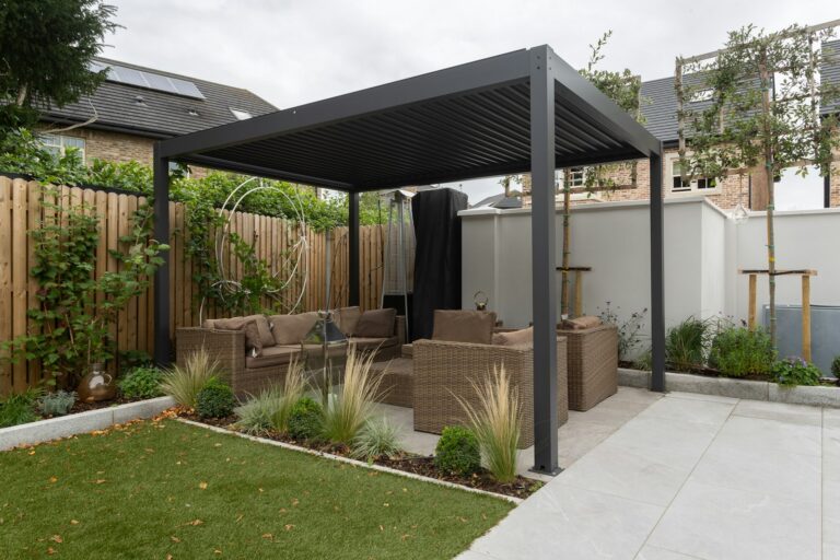 Moderne pergola med sofa og bord i haven